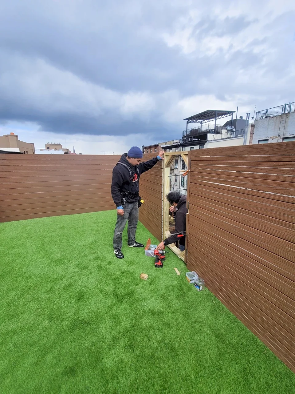 City Decks team fitting a framed opening into rooftop composite privacy screening