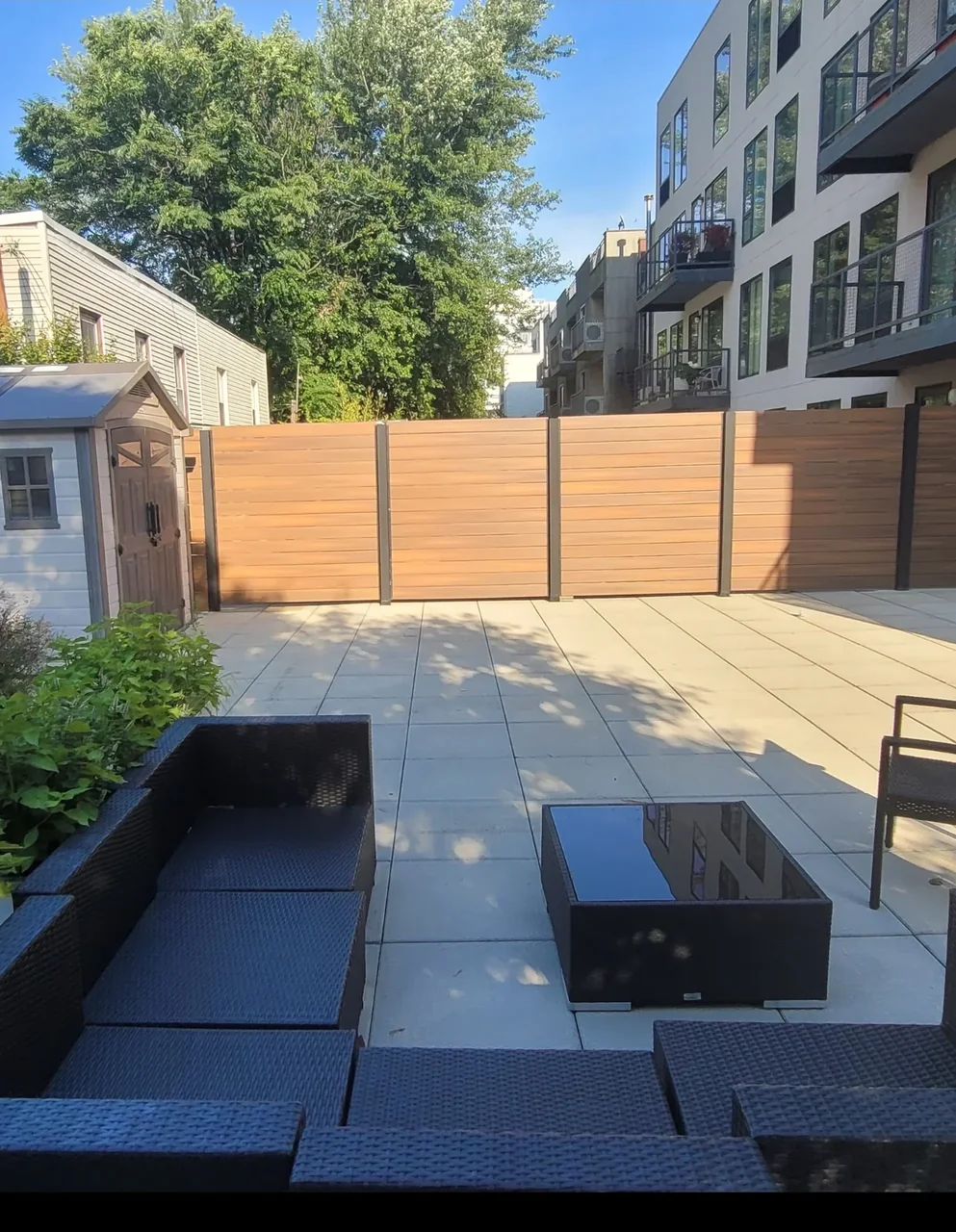 Long Island City rooftop area with pavers, composite fencing, and outdoor lounge seating
