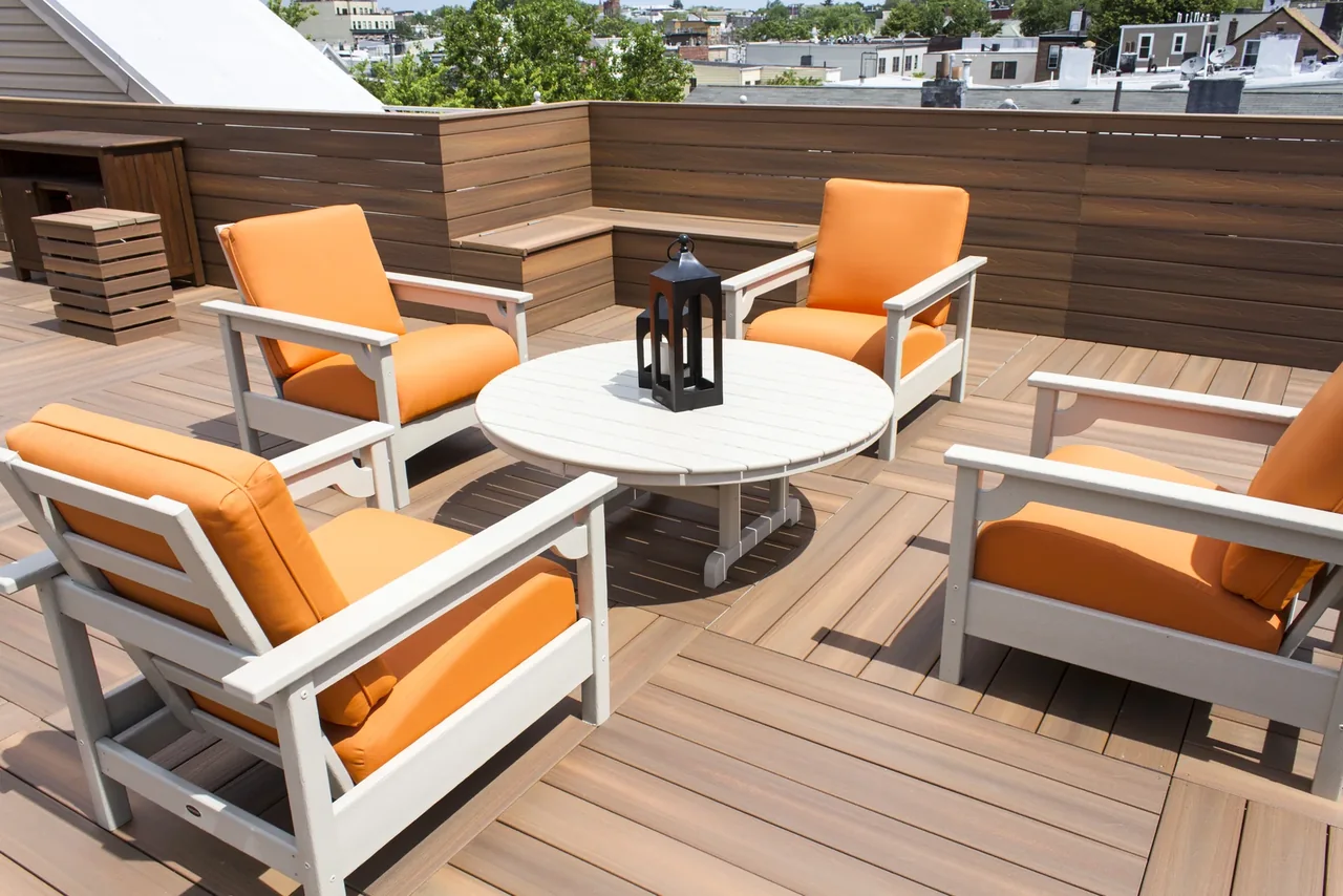 Jersey City rooftop with Fiberon decking, coordinated privacy screening and orange lounge chairs