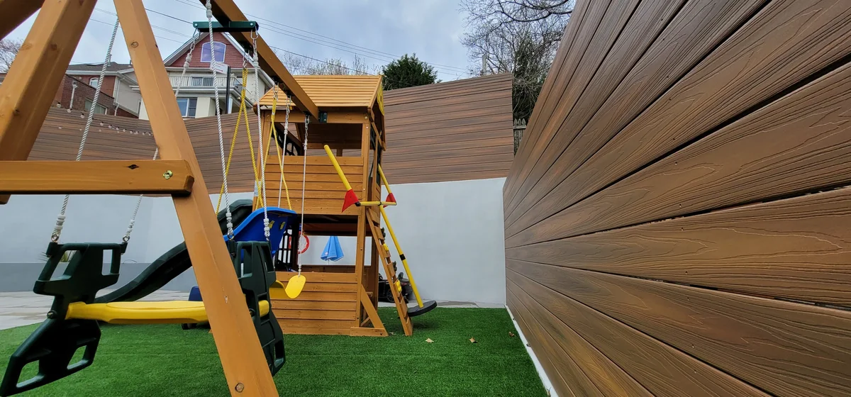 Outdoor playground with turf and horizontal privacy screening